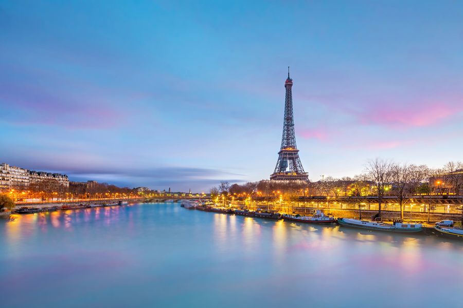 En bild av Eiffeltornet som tagits över floden i skymningen